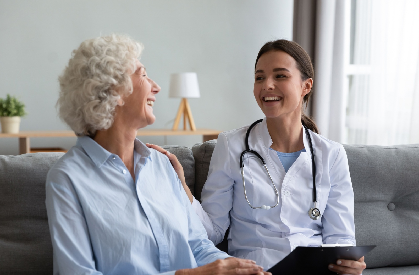 A smiling senior talking with their doctor, discussing lifestyle options to minimize the risk of developing dementia.