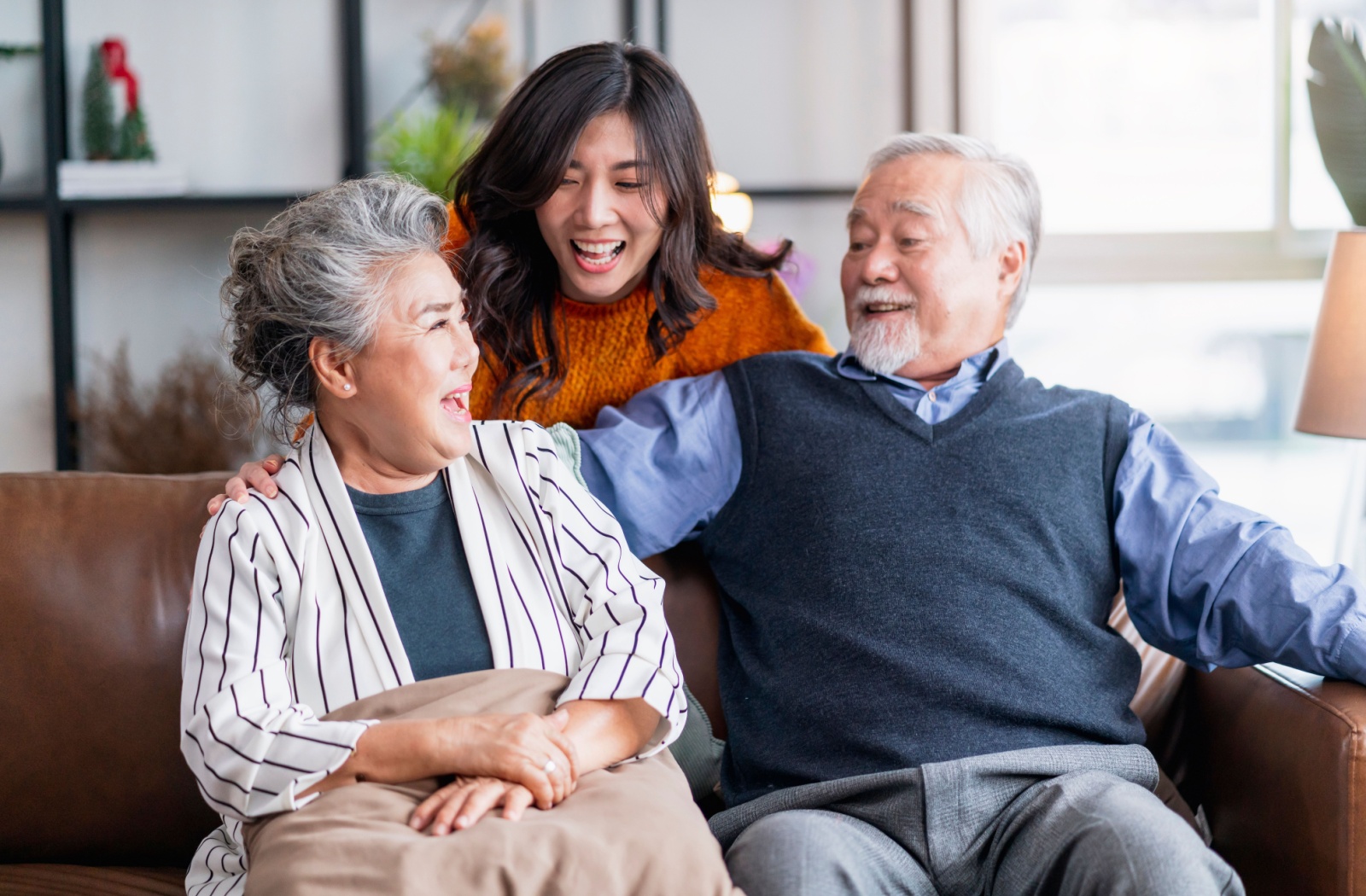 A young woman visiting her older adult parents in a nursing home.