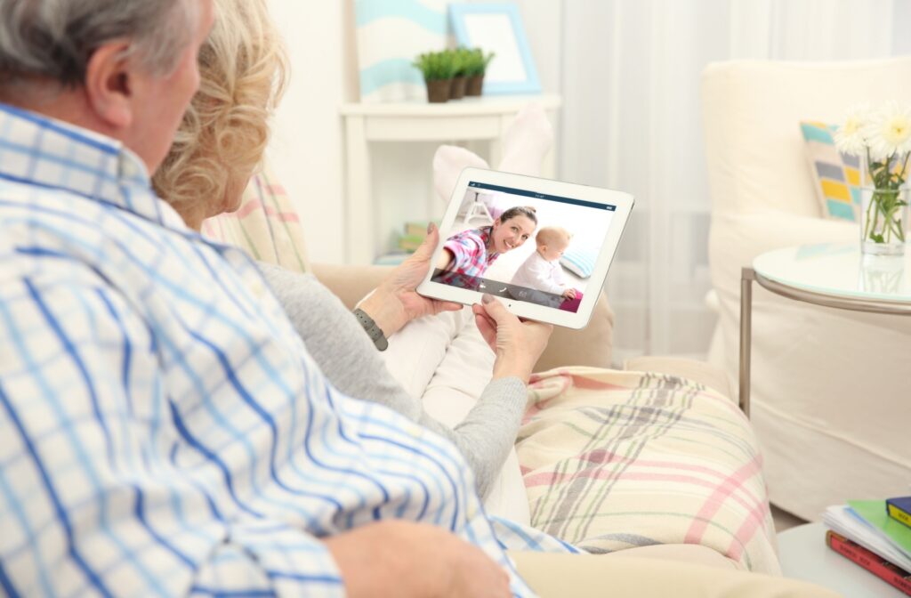 An older adult couple in a video call with their daughter and grand daughter.