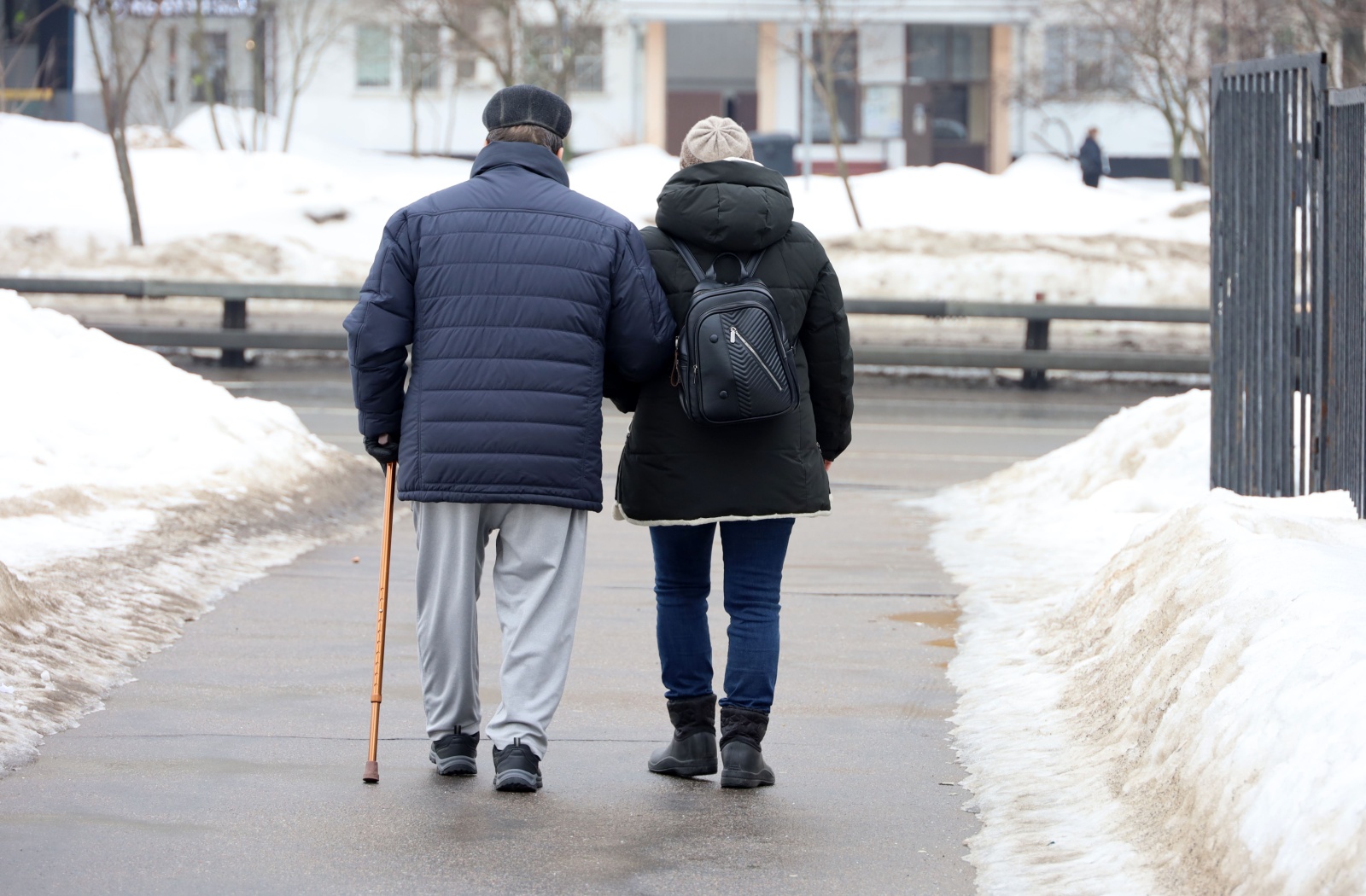 A couple of seniors wearing proper winter footwear enjoy a winter walk.