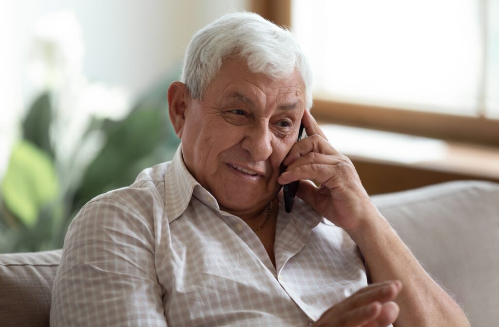 A smiling older adult talks on their senior-friendly cell phone.